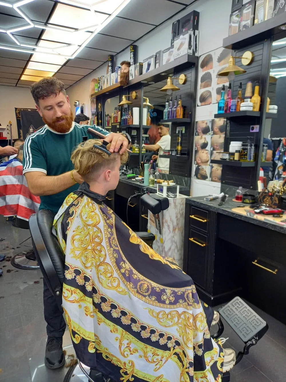 De barber knipt het haar van een klant bij Renas